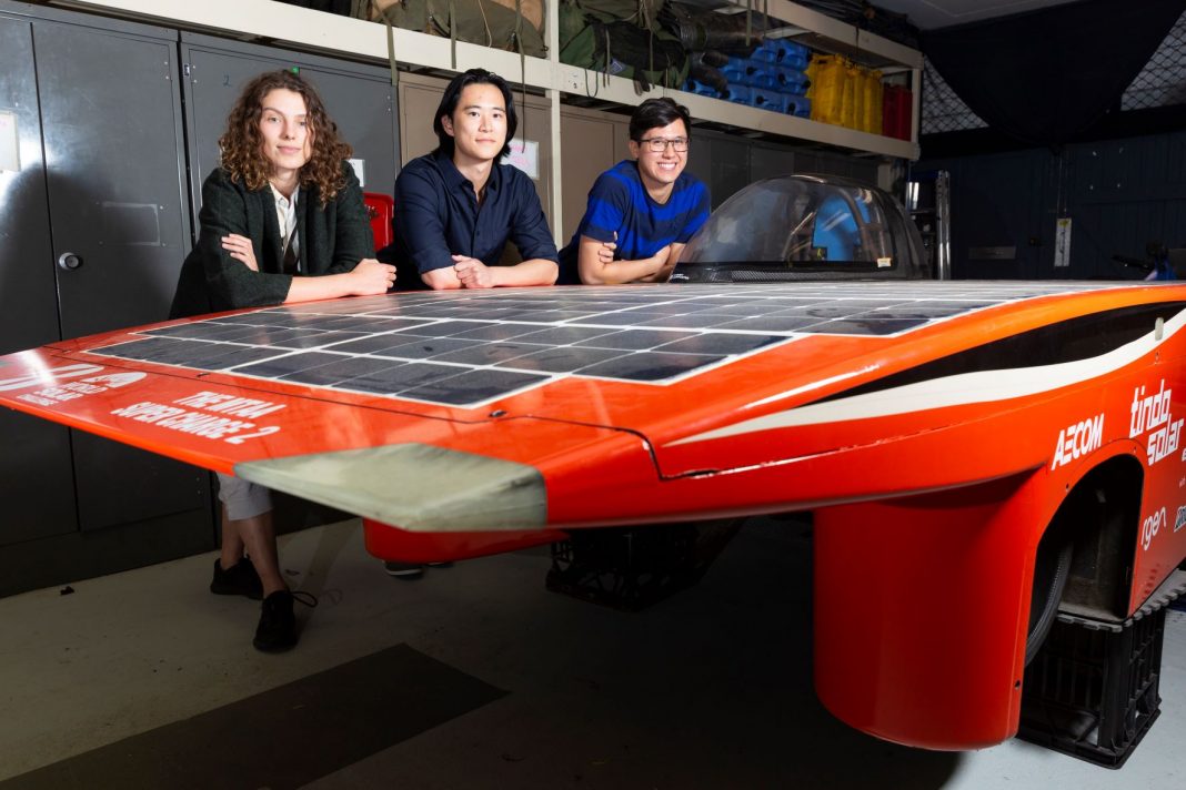 three university students with their solar car prototype