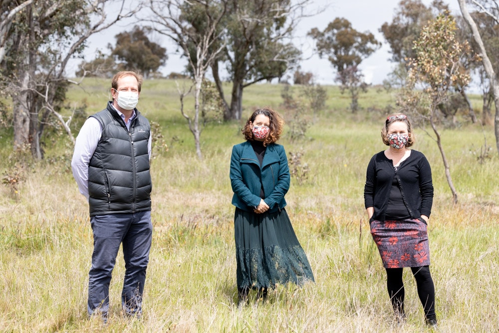 Three people at an ACT nature reserve wearing face masks