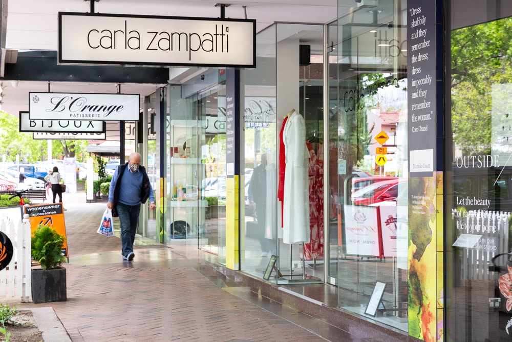 A shopper wearing a face mask is seen walking along the boutique retail shopping precinct of Manuka in Canberra