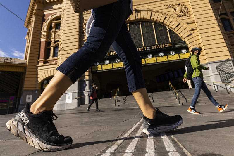People are seen walking past Flinders Street Station in Melbourne, Friday, October 22, 2021.