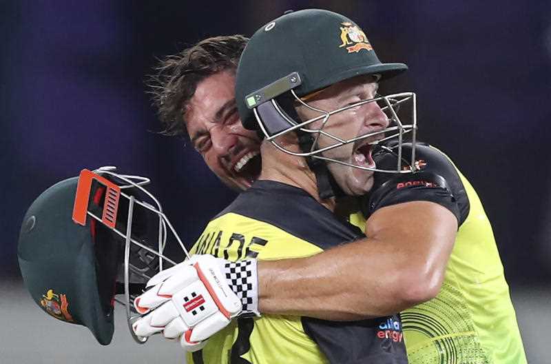 Australia's Marcus Stoinis, holding helmet, and Matthew Wade celebrate after winning the Cricket Twenty20 World Cup semi-final match between Pakistan and Australia in Dubai, UAE, Thursday, Nov. 11, 2021