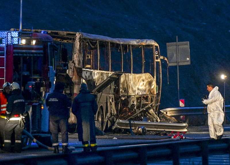 Fire fighters, police officers and investigators inspect the wreckage of a bus with North Macedonian plates that caught fire on a highway, killing at least 45 people, near the village of Bosnek, Bulgaria, 23 November 2021