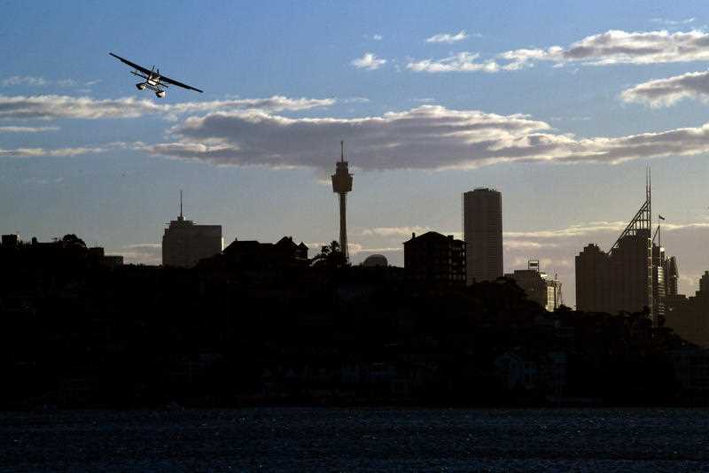 A seaplane can be seen in the sky above Rose Bay, in Sydney