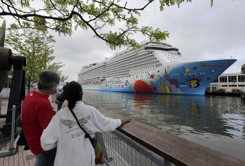 People pause to look at Norwegian Cruise Line's ship, Norwegian Breakaway, on the Hudson River, in New York
