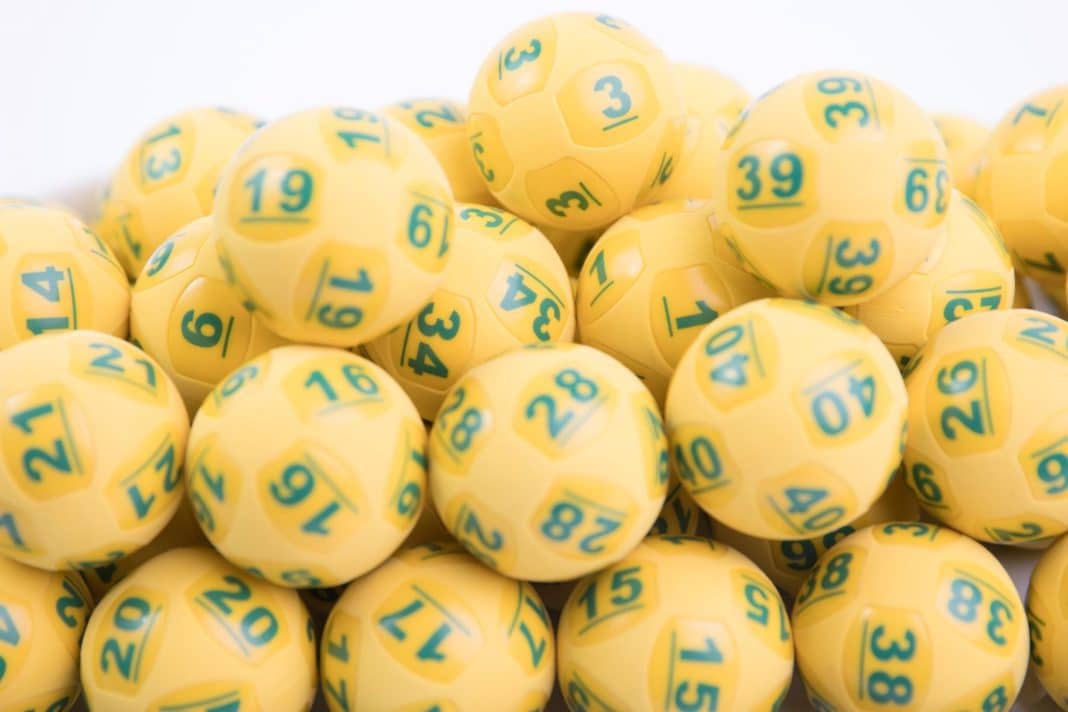 lots of yellow lottery balls with green numbers on them
