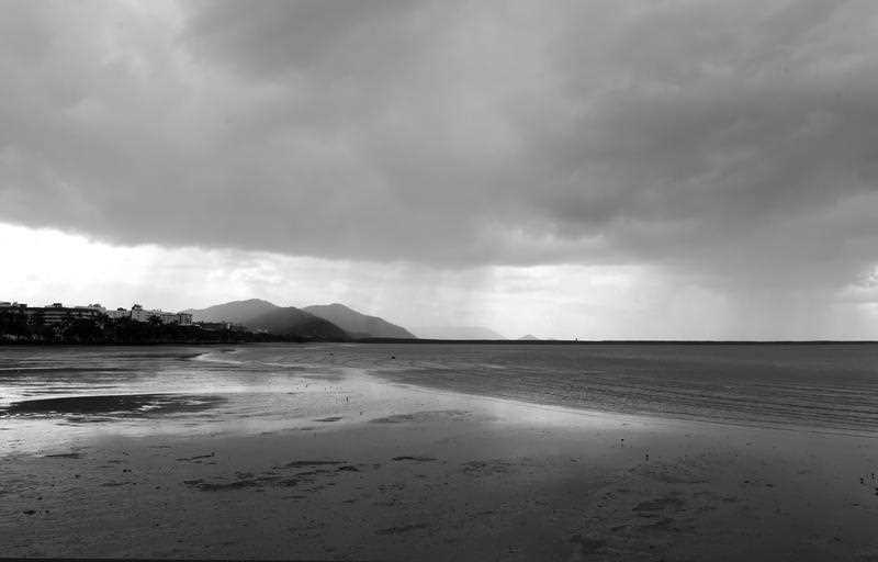 Rain clouds hover above the Cairns esplanade
