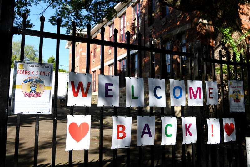 Welcome back sign on a school security fence