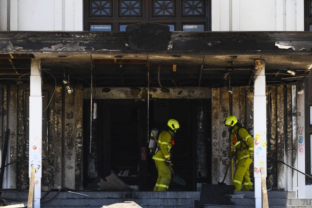 two firefighters are seen extinguishing a blaze at the front doors of Old Parliament House in Canberra on 30 December 2021