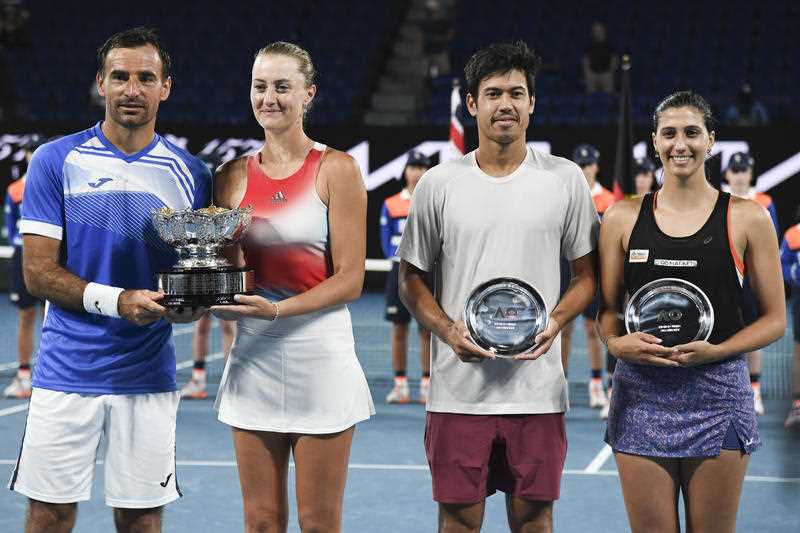 Kristina Mladenovic of France and Ivan Dodig, left, of Croatia hold their trophy after defeating Australia's Jaimee Fourlis, right, and compatriot Jason Kubler in the mixed doubles final at the Australian Open tennis championships in Melbourne, Australia, Friday, Jan. 28, 2022.(AP Photo/Andy Brownbill)
