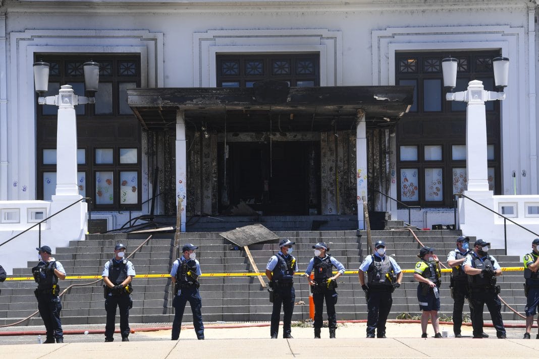 Police officers stand guard outside the fire damaged entrance to Old Parliament House in Canberra, Thursday, December 30, 2021.