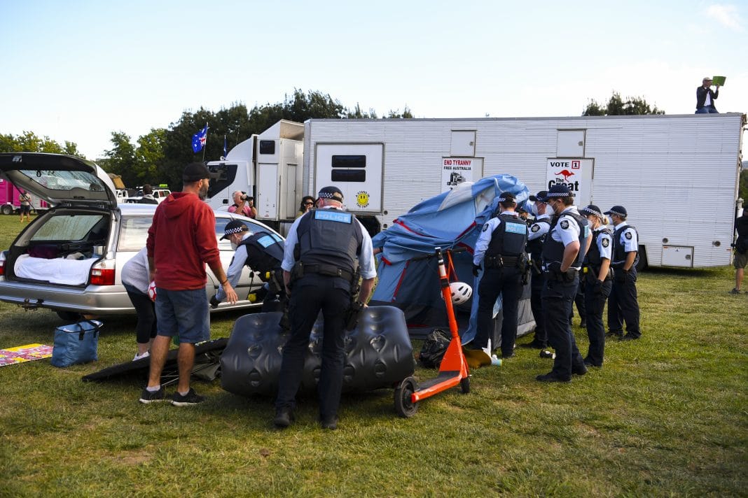 Police officers remove camping equipment and ask protesters to move on at makeshift camp next to the National Library in Canberra, Friday, February 4, 2022. A camp of protesters in Canberra has been given a move on order by police.