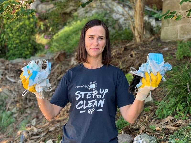 Clean Up Australia chairwoman Pip Kiernan holding up face masks found during a litter collection