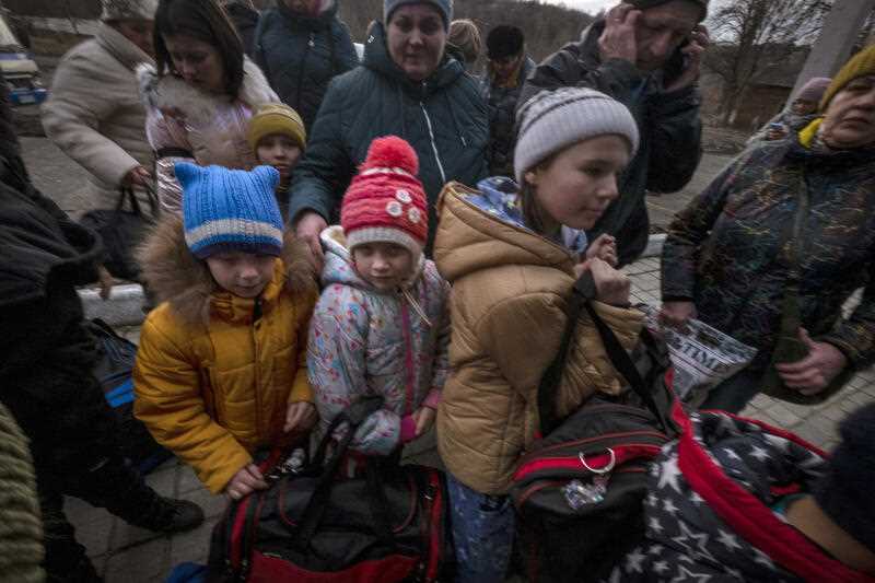Families line up to board a Kyiv bound train at a station in Severodonetsk, the Donetsk region, eastern Ukraine, Thursday, Feb. 24, 2022 as Russia launches a wide-ranging attack on Ukraine