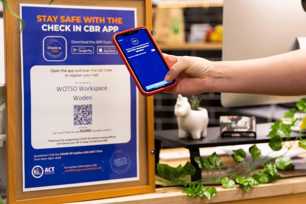 a mobile phone user is seen scanning a QR code for the Check In CBR app