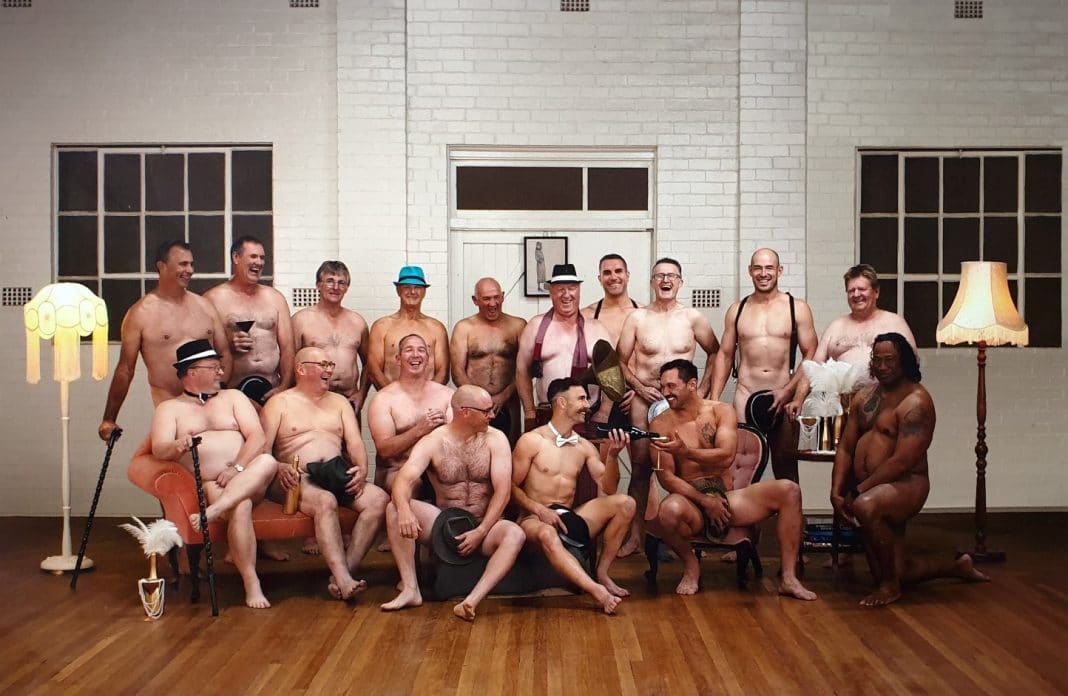 a group of 17 naked men posing for a charity calendar with strategically placed hats