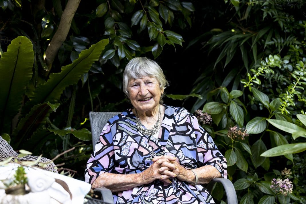 beautiful smiling 95-year-old woman sitting in her leafy garden