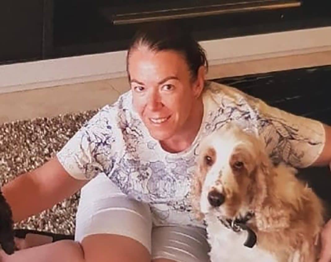 Missing fraudster Melissa Caddick is seen sitting on the floor with a cocker spaniel dog