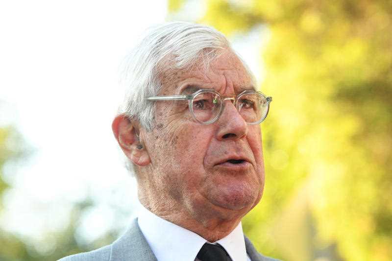 High-profile barrister Julian Burnside, a senior male in a suit and wearing glasses is seen speaking to the media