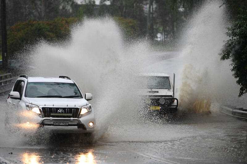 Cars are seen driving through a partially flooded road at Warragamba, west of Sydney, Wednesday, March 2, 2022.