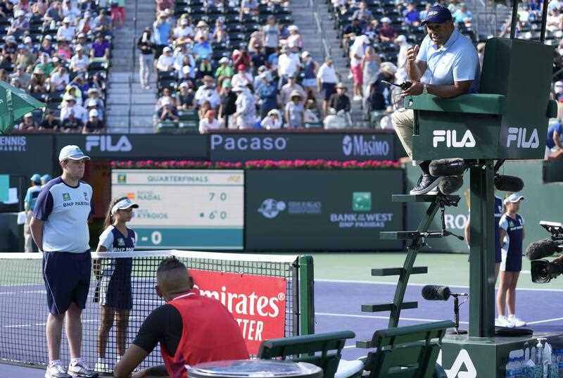 Chair Umpire Carlos Bernardes (R) speaks with Nick Kyrgios of Australia during a changeover in the match against Rafael Nadal of Spain during the BNP Paribas Open tennis tournament at the Indian Wells Tennis Garden