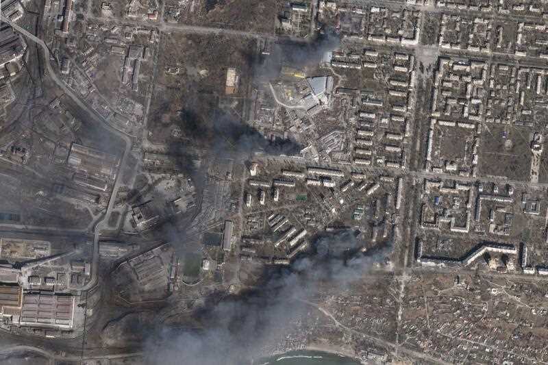 In this satellite photo, multiple civilian buildings burn amid Russian strikes on the Livoberezhnyi District of Mariupol, Ukraine, Sunday, March 20, 2022