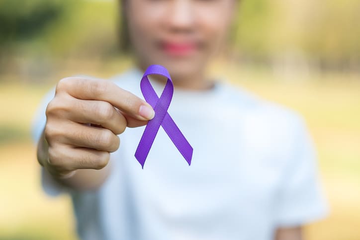 woman holding purple ribbon to mark International Epilepsy Awareness Day