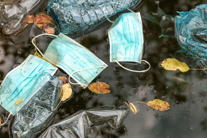 .Litter including plastic bottles and discarded protective face masks pollute river water.
