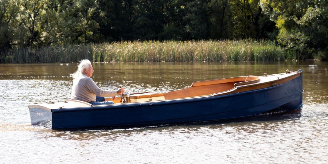 woman with long white hair in beautiful old wooden boat on Lake Burley Griffin, Canberra