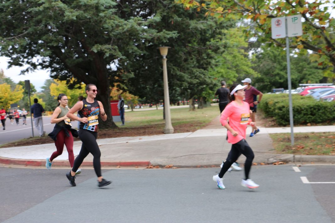 several women are seen running in a marathon in Canberra in autumn