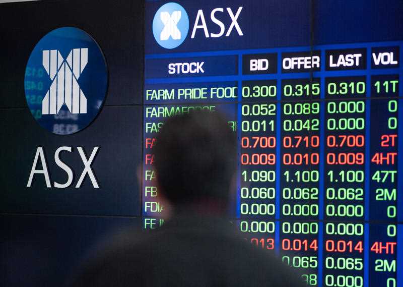 A man watching digital market boards at the Australian Securities Exchange (ASX) in Sydney