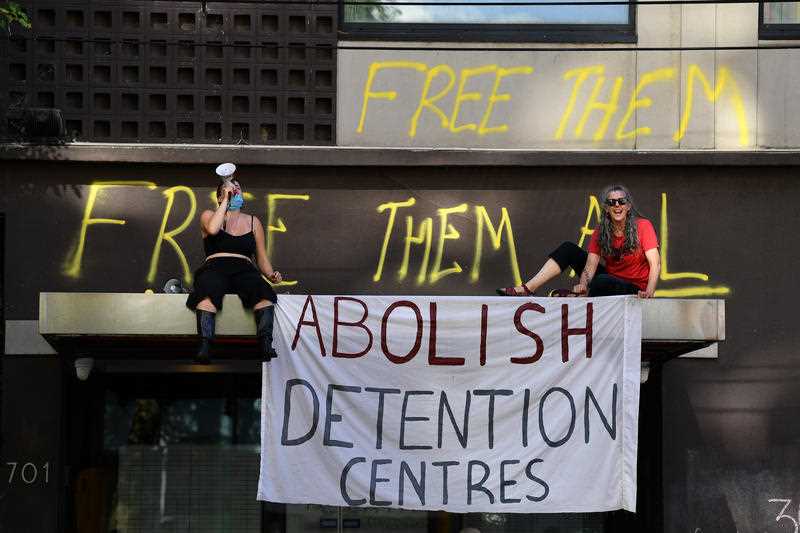 Protesters are seen outside of the Park hotel quarantine facility in Melbourne