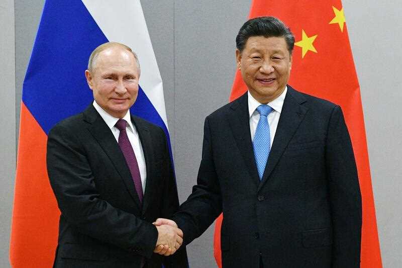 Russian President Vladimir Putin, left, and China's President Xi Jinping shake hands