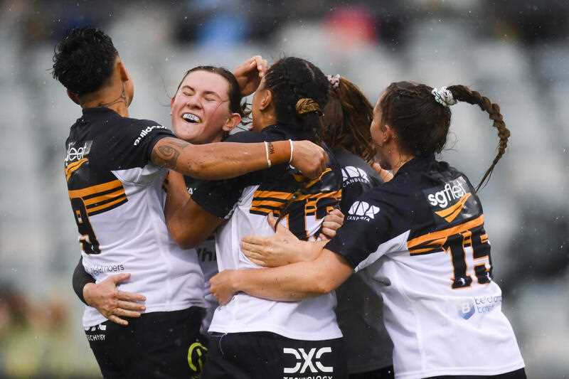 Jemima McCalman of the Brumbies celebrates with team mates after scoring a try
