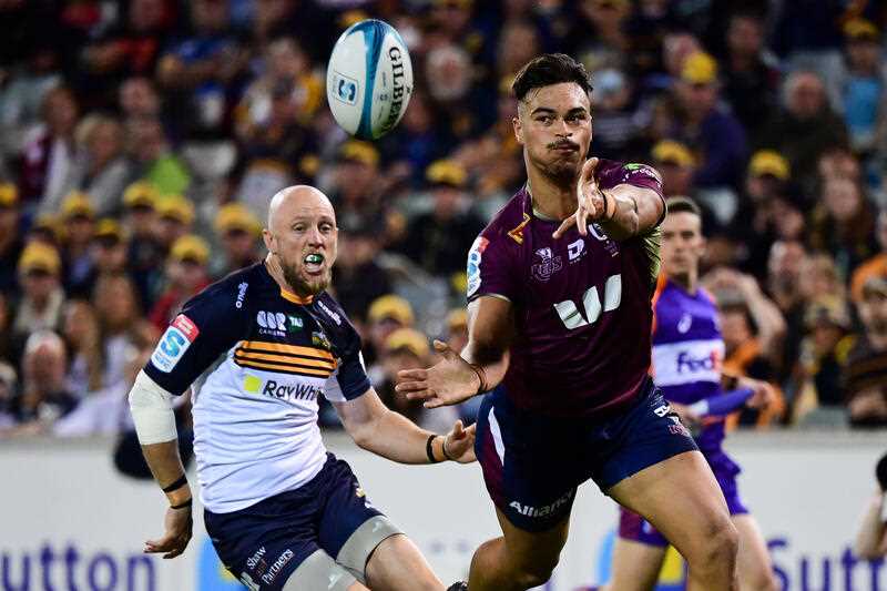 Jesse Mogg of the Brumbies watches Jordan Petaia of the Queensland Reds pass the ball