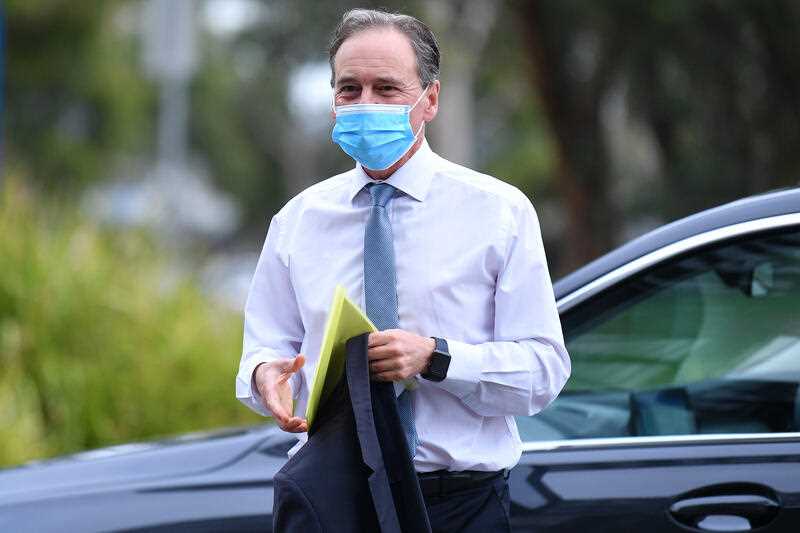 Federal Health minister Greg Hunt is seen wearing a face mask as he arrives for a photo opportunity in Melbourne