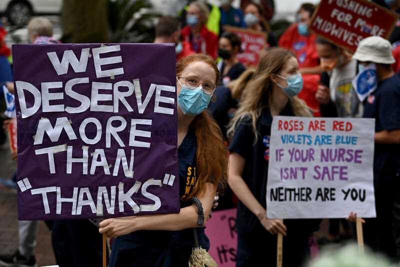 Nurses and midwives hold placards during a nurses’ strike rally at NSW Parliament House in Sydney, Thursday, March 31, 2022