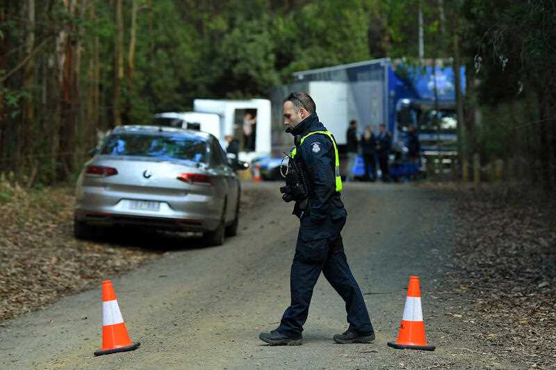 A Victorian Police officer mans a checkpoint near the command post at Blair's Hut at Mount Disappointment in Victoria near a fatal helicopter crash site