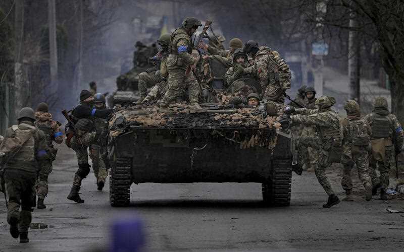 Ukrainian servicemen climb on a fighting vehicle outside Kyiv, Ukraine, Saturday, April 2, 2022.