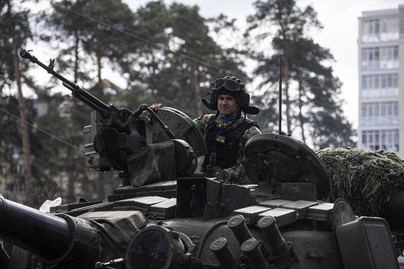 A Ukrainian serviceman drives on a tank in Irpin, in the outskirts of Kyiv, Ukraine, Monday, April 11, 2022
