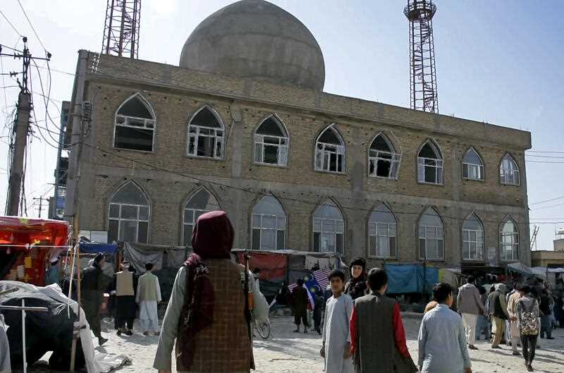 a Taliban fighter standing guard outside the site of a bomb explosion inside a mosque, in Mazar-e-Sharif province, Afghanistan, Thursday, April 21, 2022.