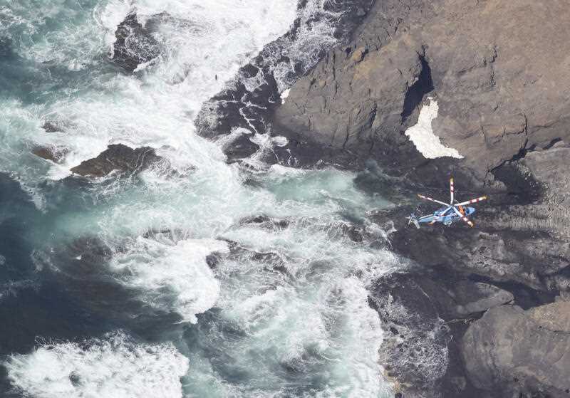 An aerial photo shows a search in Shari Town, Hokkaido Prefecture on April 24, 2022. The Japan Coast Guard said on the same day that it found more than ten people on the sea and on rocks around the tip of Cape Shiretoko, where a sightseeing boat with 26 people aboard went missing after issuing emergency calls on a previous day