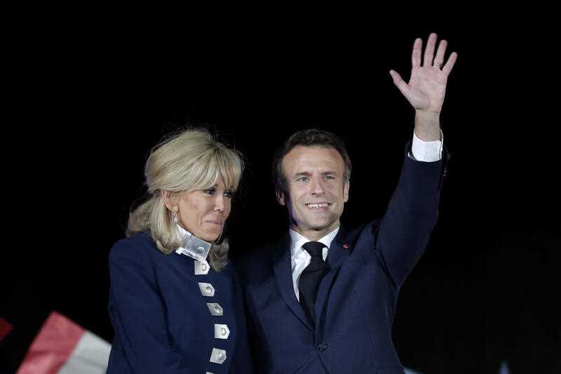 French President Emmanuel Macron waves with his wife Brigitte Macron after reports of his reelection Sunday, April 24, 2022 in Paris.