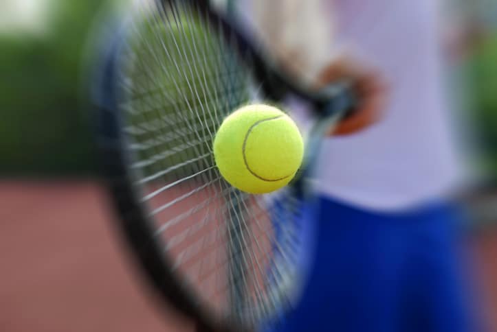 Close-up tennis racket and ball