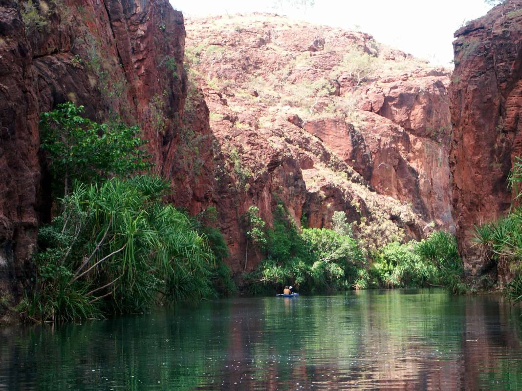 Canoeists are dwarfed by the towering cliffs of the gorge which reach 60 metres high in some parts, as they explore the creek and its surrounding oasis at Boodjamulla (Lawn Hill) National Park in far north-west Queensland