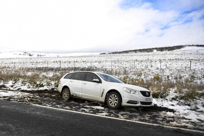 A car is seen on the Monaro Highway after sliding off the road in snowy conditions near Cooma, NSW, Thursday, June 10, 2021