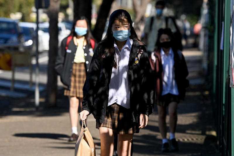 Teenage students are seen wearing face masks to school