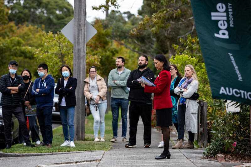 A sales agent is seen as bidders look on during a property auction