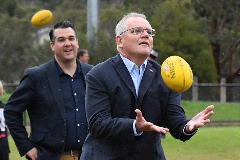 Prime Minister Scott Morrison catches a ball at Norwood Sports Club on Day 34 of the 2022 federal election campaign, in Norwood in Melbourne