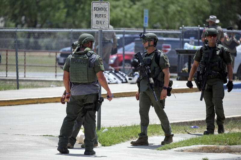 Law enforcement personnel stand outside Robb Elementary School following a shooting, Tuesday, May 24, 2022, in Uvalde, Texas.