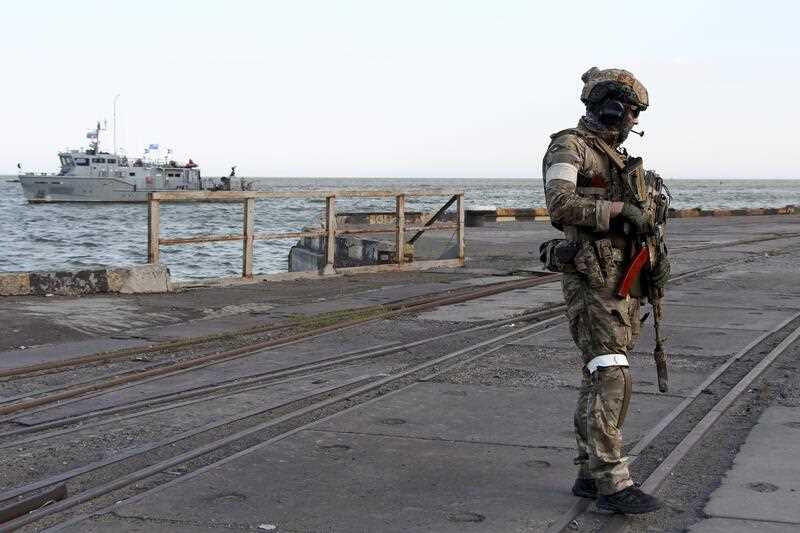 A Russian serviceman stands guarding an area of the Mariupol Sea Port in Mariupol